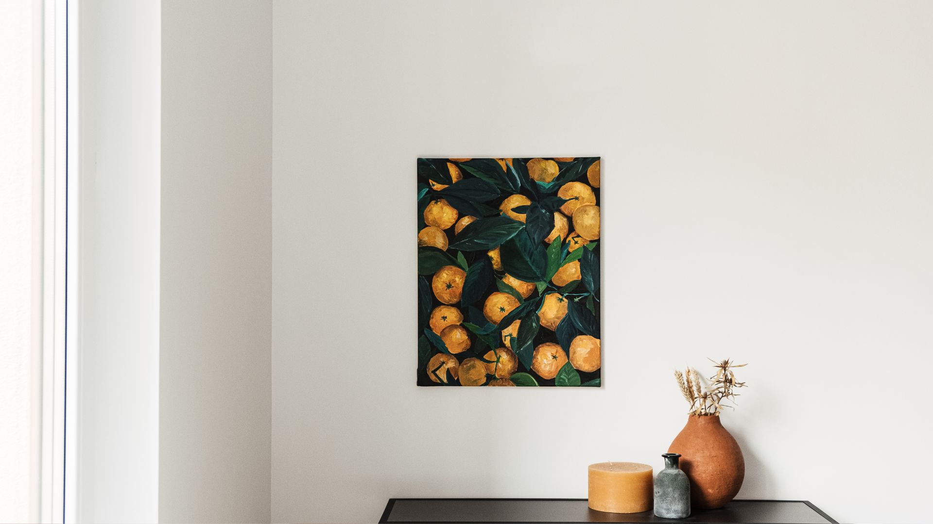 A painting of oranges on a white wall