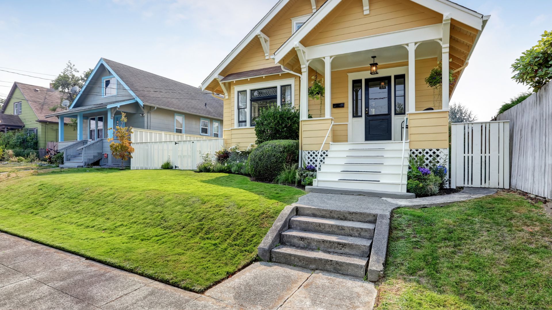 A yellow house with a white picket fence