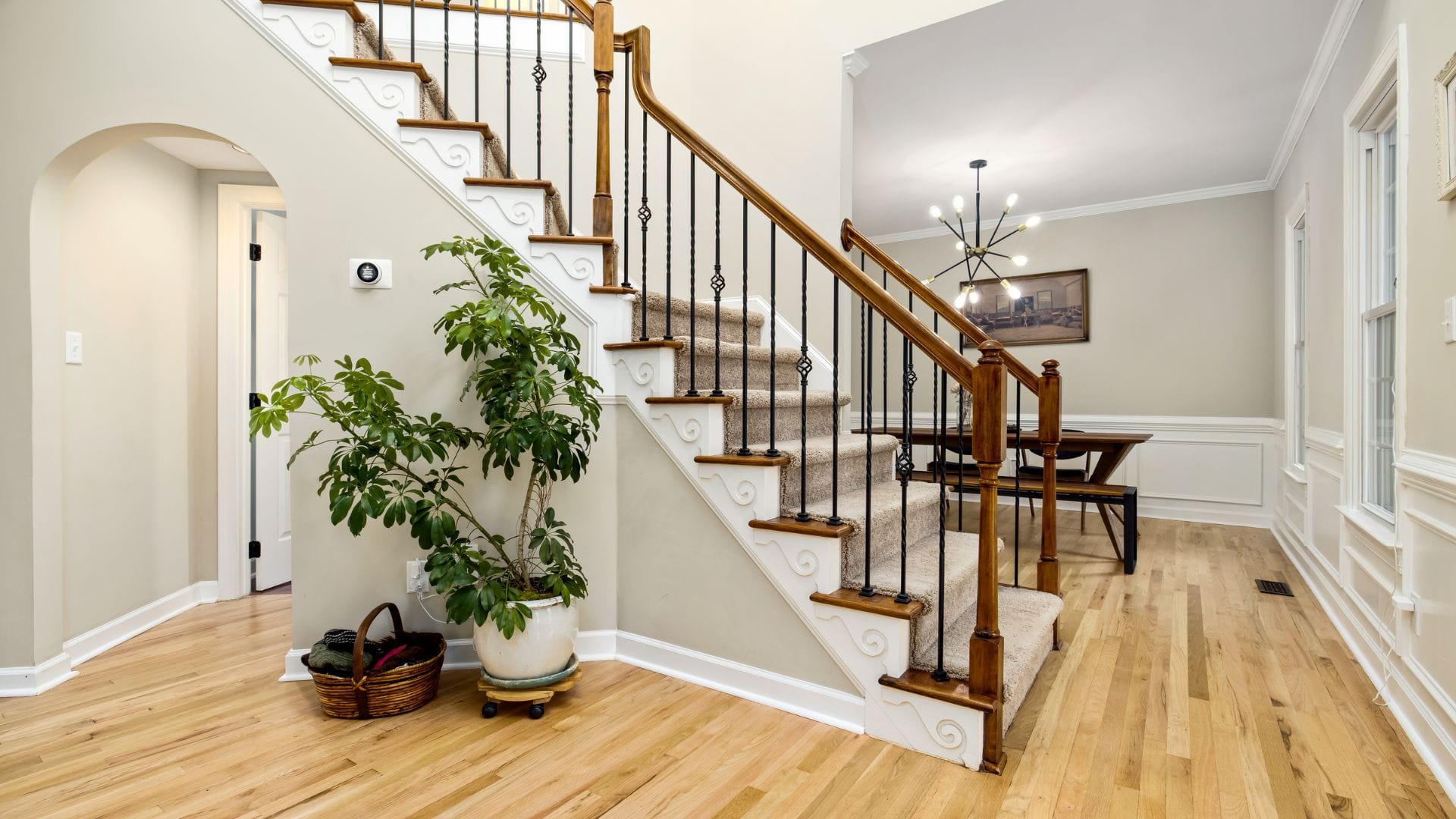 Entry foyer with freshly painted white staircase trim and wainscoting