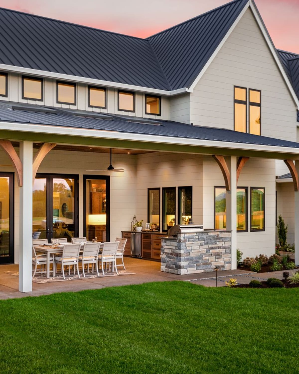 Freshly painted two-story home glowing at dusk on a calm summer evening — prime exterior painting weather