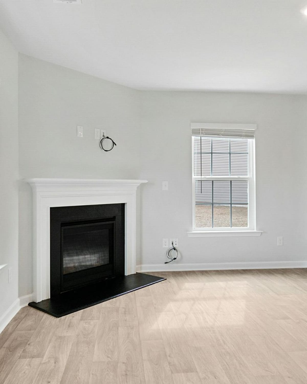 Freshly painted empty living room with light gray walls, white trim and a fireplace — a whole-house interior in Great Falls