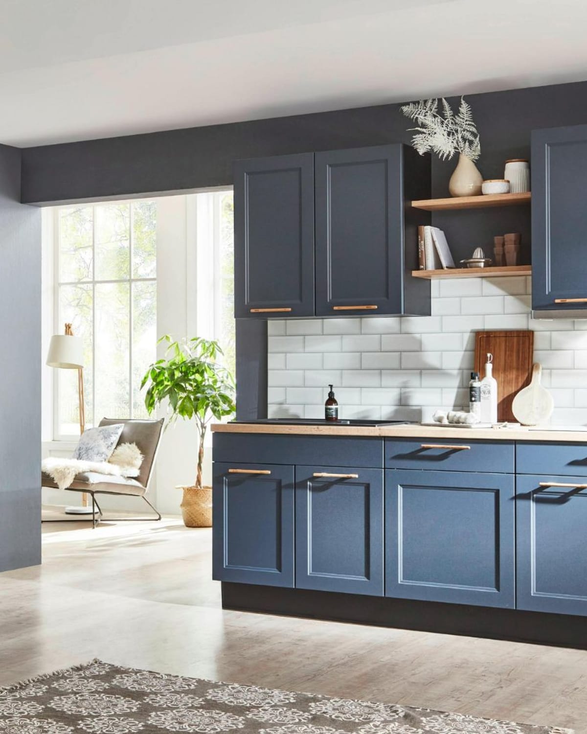 Navy blue painted kitchen cabinets with wood shelving and white tile after a professional cabinet repaint